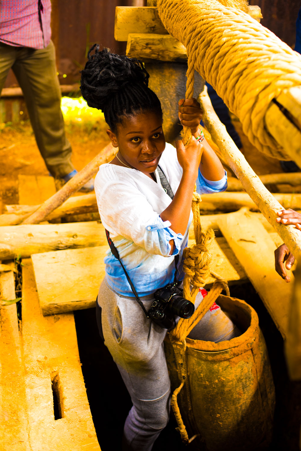 Young lady holds rope while entering a gold mine in Western Kenya