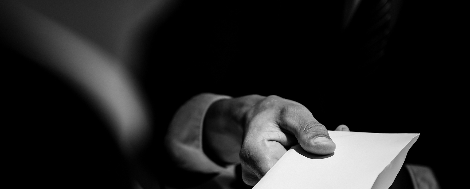 Picture of a businessman's hand holding money to give a bribe